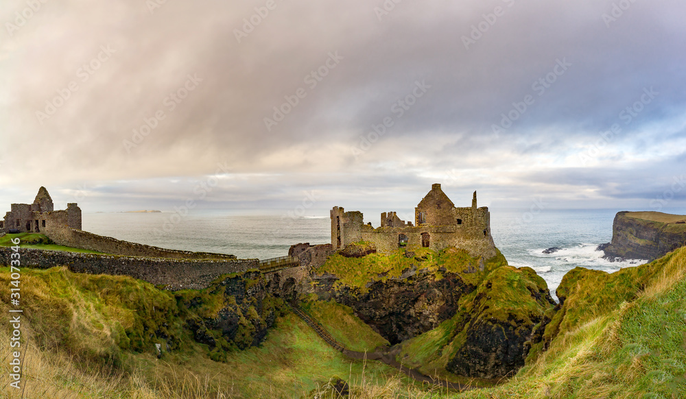 Ruined medieval Dunluce Castle on the cliff dramatic sky. Part of Wild Atlantic Way, Bushmills, County Antrim, Northern Ireland. Filming location of popular TV show, Game of Thrones, Castle Greyjoy
