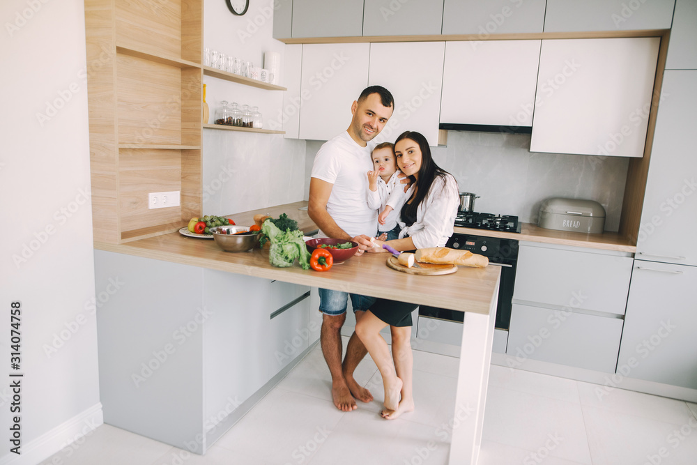Family in a kitchen. Beautiful mother with little son. Father in a white t-shirt. Family in a kitchen. Beautiful mother with little son. Father in a white t-shirt.