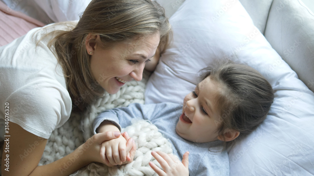 pretty mother tells fairy tale to daughter under blanket pretty mother tells fairy tale to daughter under blanket