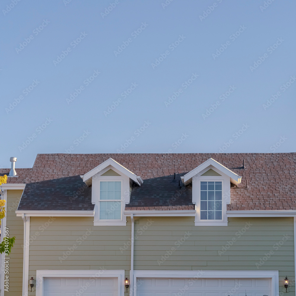 Square frame Two small dormer windows in an urban house Square frame Two small dormer windows in an urban house