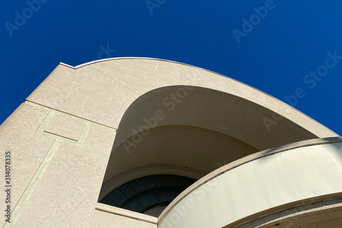 top corner of building architecture facade with arches and blue sky