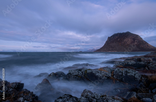 blaue Stunde am Vestfjord in Norwegen, felsige Küstenlandschaft mit Blick auf die Lofoten, lange Belichtungszeit mit verwischenden Wellen photo