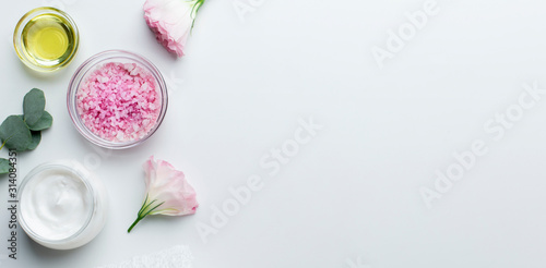 Cosmetic products in jars of rose petals and pink salt