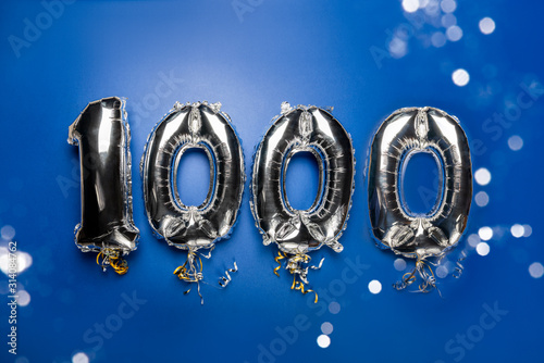 Fotografía Balloon Bunting for celebration Happy 1000th Anniversary made from Silver Number Balloons on blue background