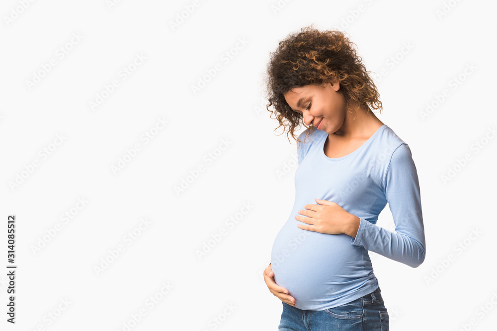 Enjoying pregnancy. Expectant woman embracing her belly - obrazy, fototapety, plakaty 