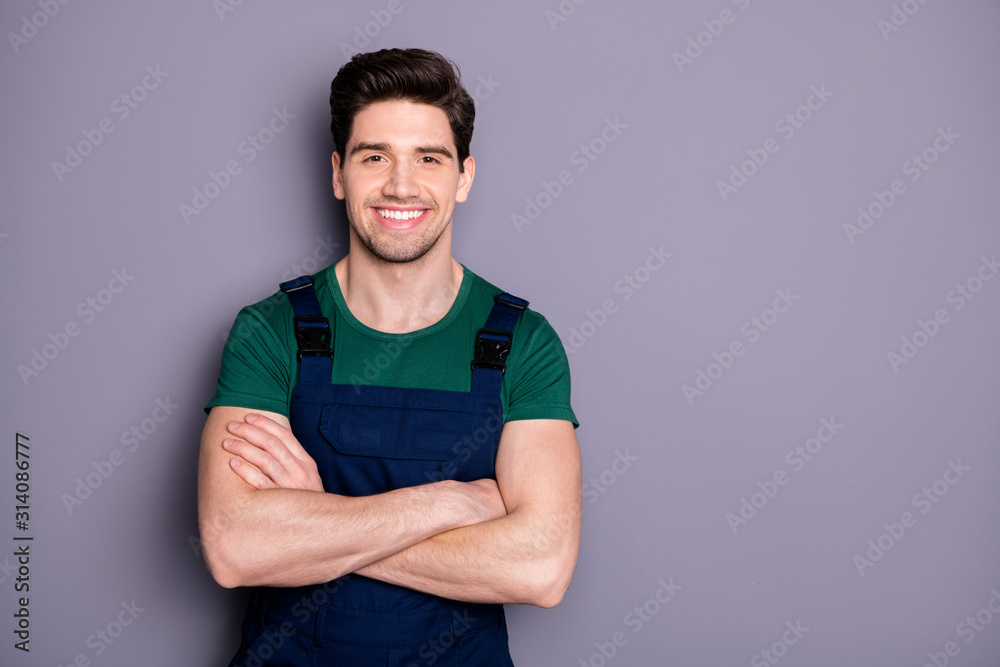 Fototapeta Zdjęcie przystojny męski facet mięśni trzymać ręce skrzyżowane pewny siebie najlepszy robotnik wykwalifikowany inżynier nosić zielony t-shirt niebieski ogrodniczki bezpieczeństwa na białym tle szary