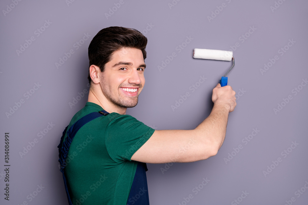 Close-up profile side view portrait of his he nice attractive brunette cheerful cheery guy making renovation restoration new design painting wall isolated over gray pastel color background
