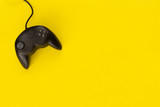 Black console gamepad of video game on yellow background. concept of fun and strategy.