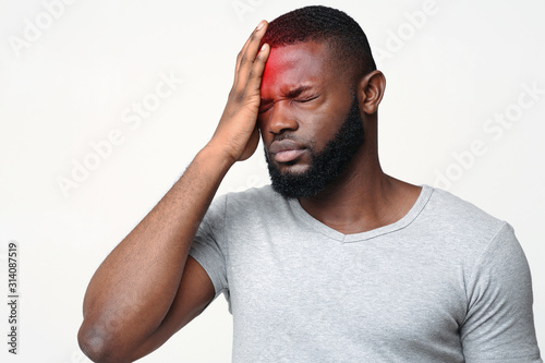 Young man suffering from terrible strong head pain photo