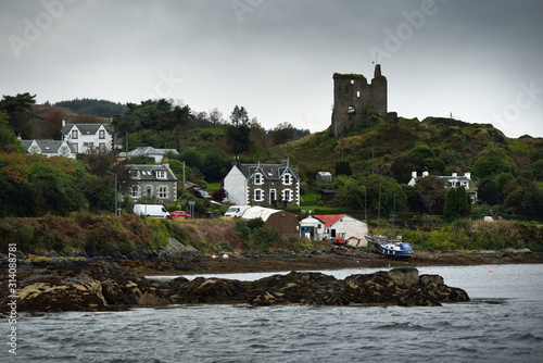 A view of the shores of Tarbert from the water. Country houses, yachts and fishing boats close-up. Scotland, UK photo