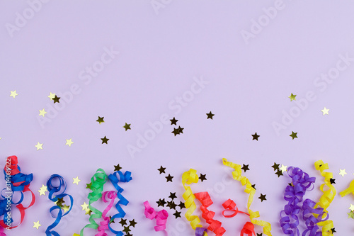 Festive party border or frame of colorful spiral streamers and confetti on pink background © Анна Мартьянова