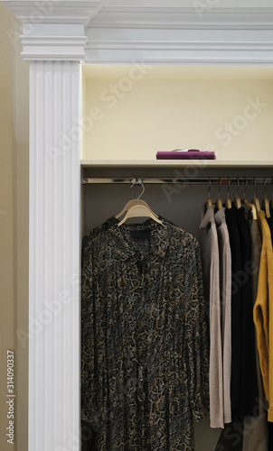 Wardrobe with stylish clothes hanging on rack.