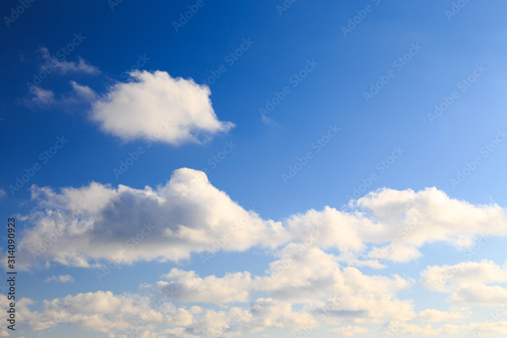 Naklejka premium Bright cumulus clouds against the blue sky. Sunset sky Natural background. seascape