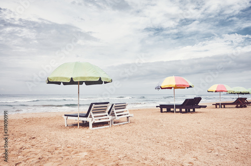 Sunbeds with umbrellas on an empty beach  color toning applied  Sri Lanka.