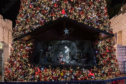 Canvastavla Night view of a Christmas scene made of dolls in a niche decorated for the celeb