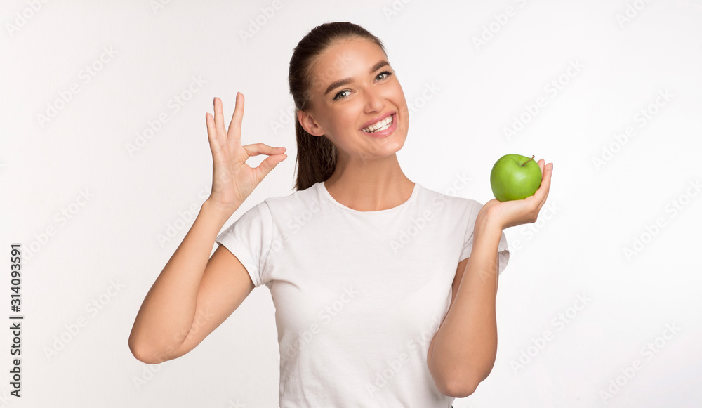 Cheerful Woman Holding Apple Fruit Gesturing Okay On White Background Cheerful Woman Holding Apple Fruit Gesturing Okay On White Background