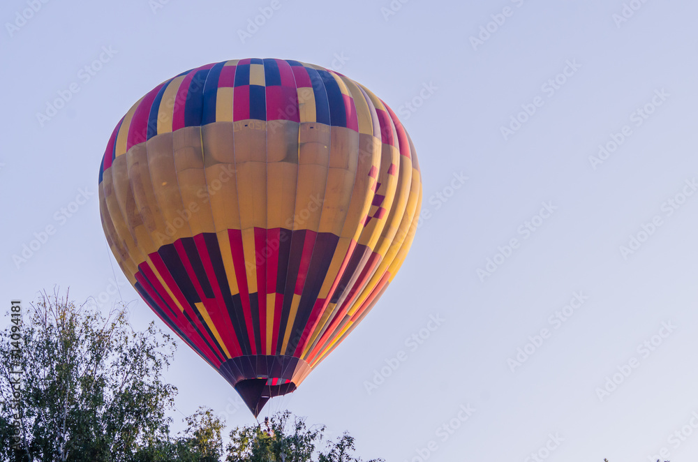 Naklejka premium hot air balloon is flying at sunrise. romantic balloon flights