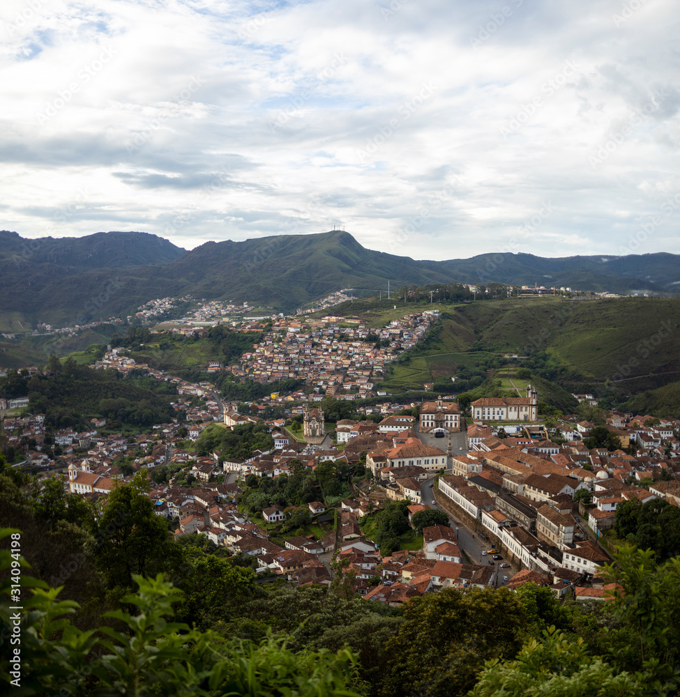 Early morning panoramic view of colonial mining city centre Ouro Preto in Minas Gerais, Brazil, with surrounding mountains in the background seen from a high altitude and large distance