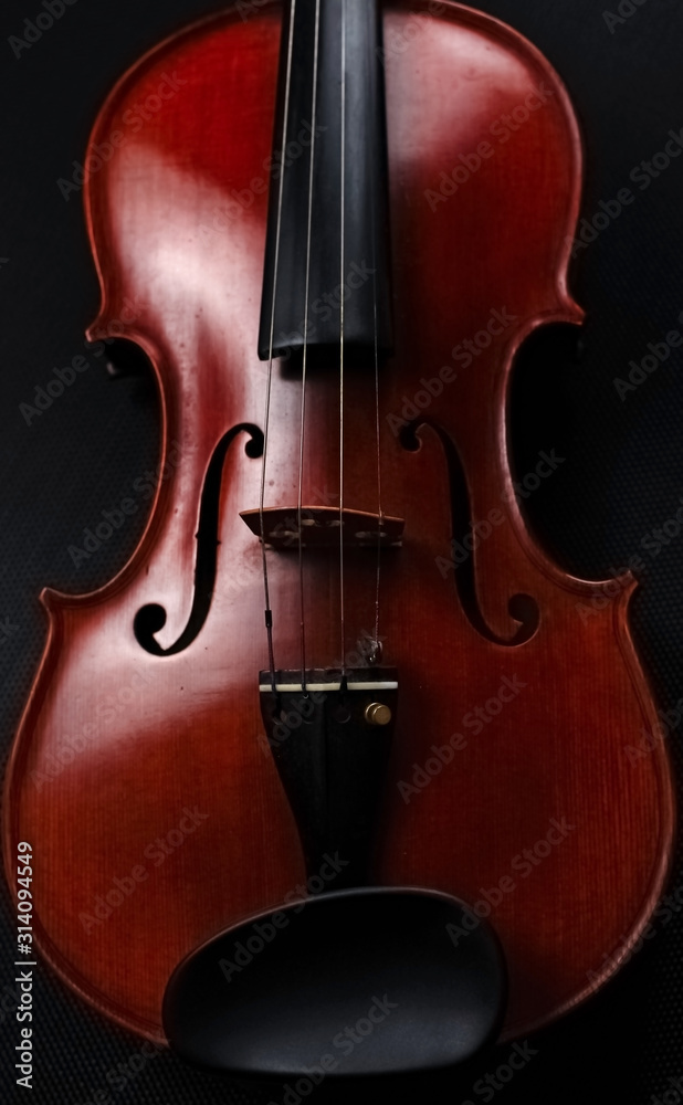 Front side of violin put on black canvas,blurry light around Front side of violin put on black canvas,blurry light around