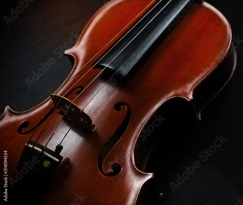 Front side of violin put on black canvas,blurry light around