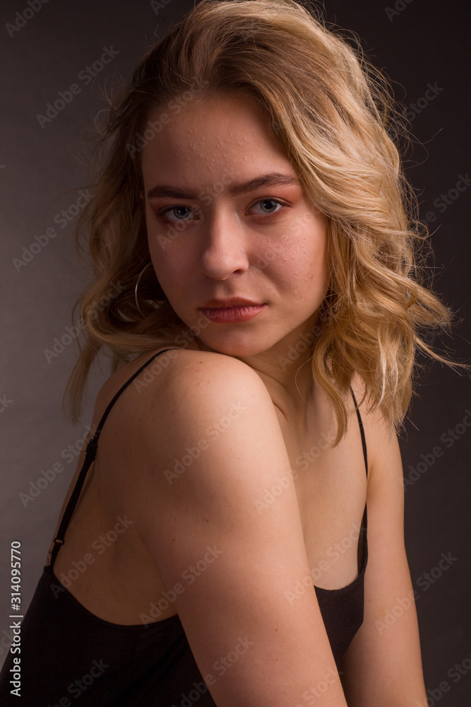Studio portrait of blonde on a dark background in a dark dress Studio portrait of blonde on a dark background in a dark dress