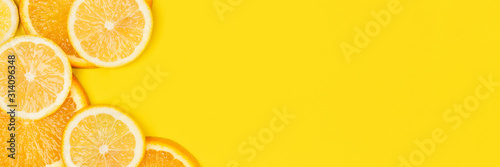 Juicy citrus on a yellow background. Bright vitamin photo. Copy space, web-banner format.