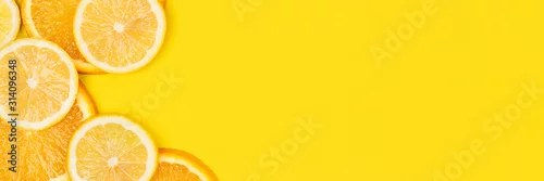 Obraz  z motywem Juicy citrus on a yellow background. Bright vitamin photo. Copy space, web-banner format.