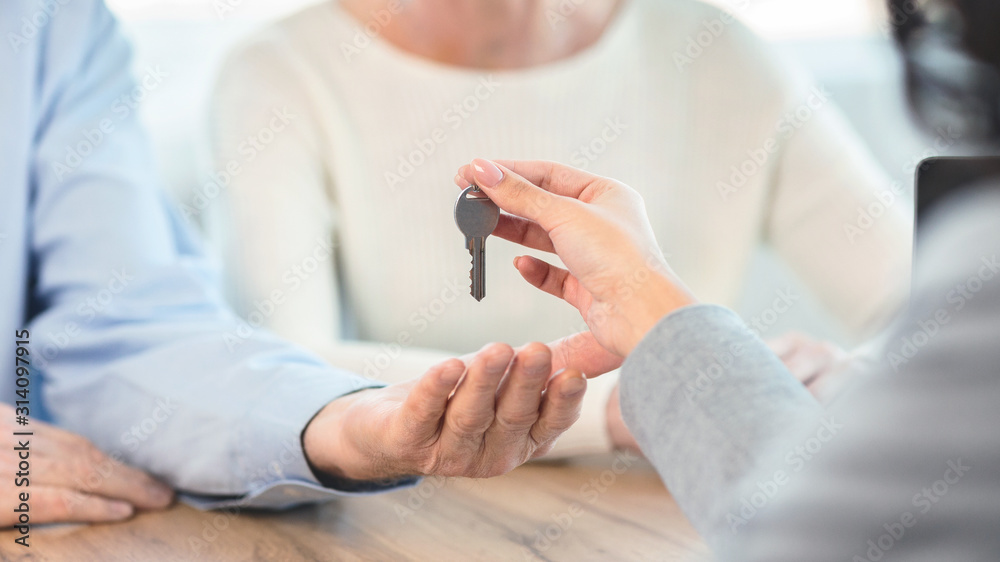Happy elderly couple getting key from their new place