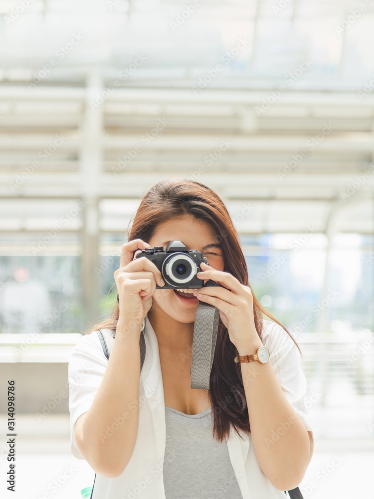 Close up portrait of a beautiful hipster Asian woman with a camera taking photos with smile, Happy and travel concept.