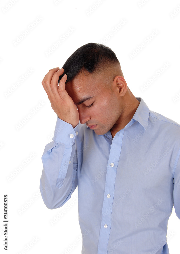 Young businessman standing in a blue shirt thinking Young businessman standing in a blue shirt thinking