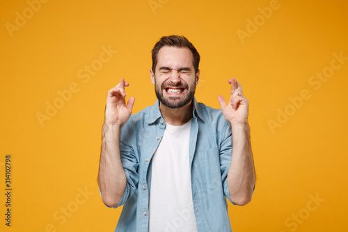 Bilde på lerret Young bearded man in blue shirt posing isolated on yellow orange background