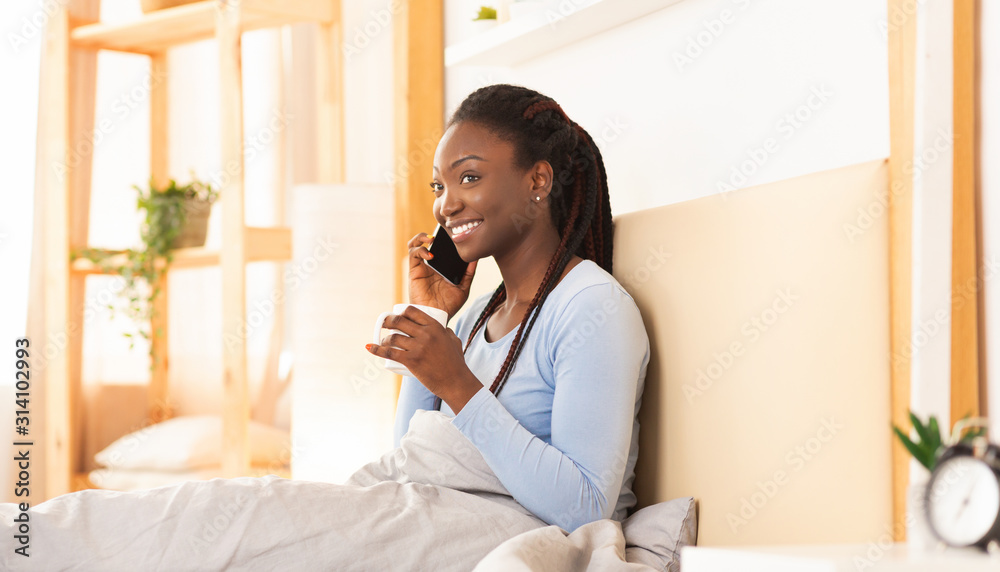 African American Woman Chatting On Cellphone Having Coffee In Bed African American Woman Chatting On Cellphone Having Coffee In Bed
