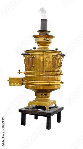 old copper samovar with a chimney from which smoke comes stands on a small table isolated on a white background
