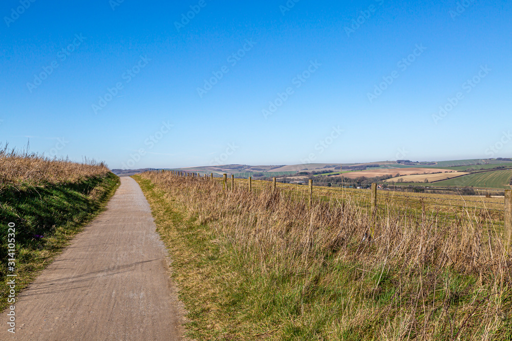 A pathway alongside fields in the South Downs, on a sunny winters day