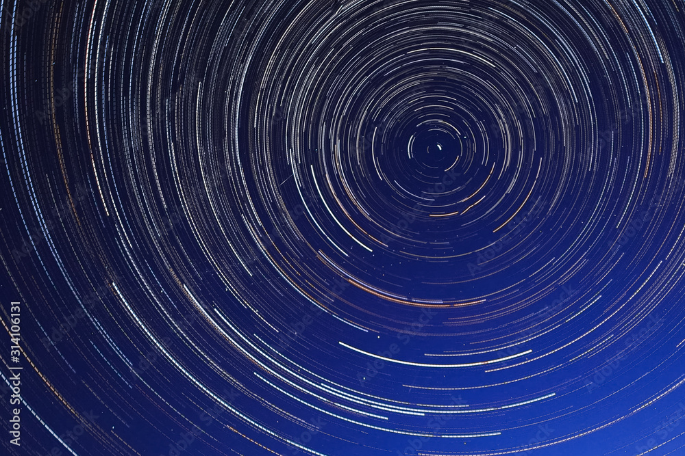 Fototapeta premium Long exposure starry sky, twisted tracks of stars.