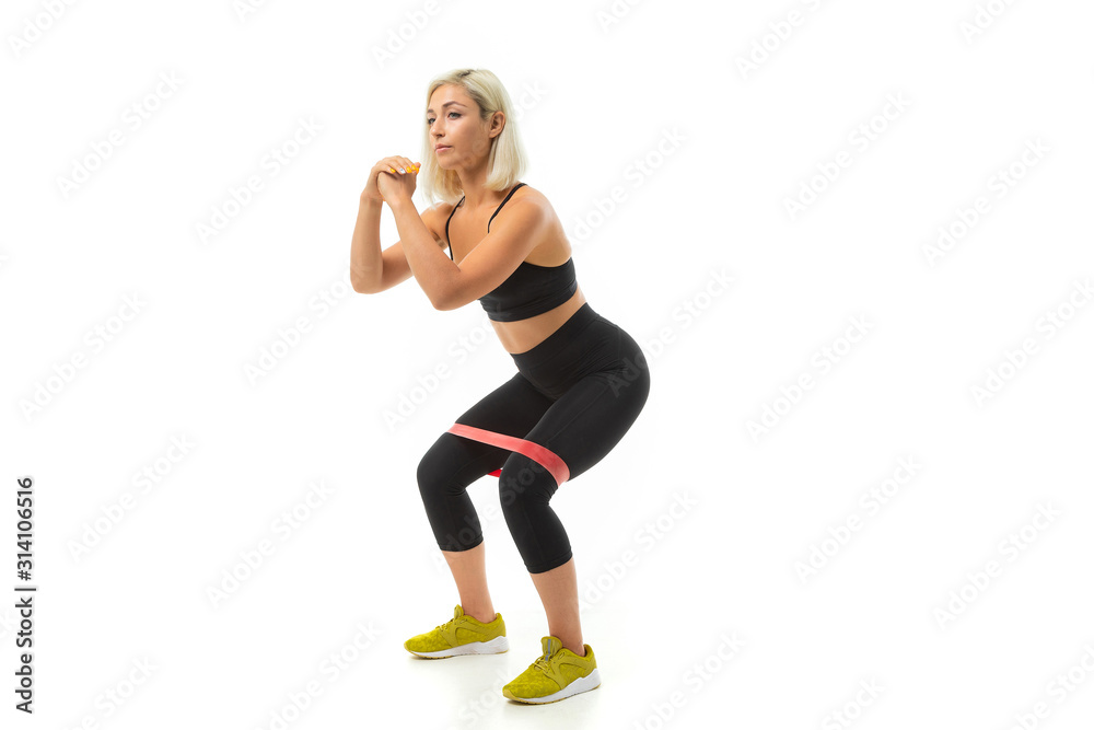 Sport caucasian girl do sports with elastic band expander, portrait isolated on white background Sport caucasian girl do sports with elastic band expander, portrait isolated on white background