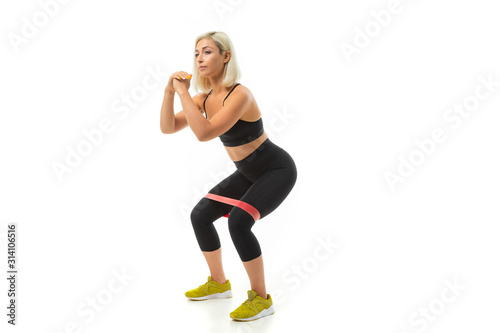 Sport caucasian girl do sports with elastic band expander, portrait isolated on white background