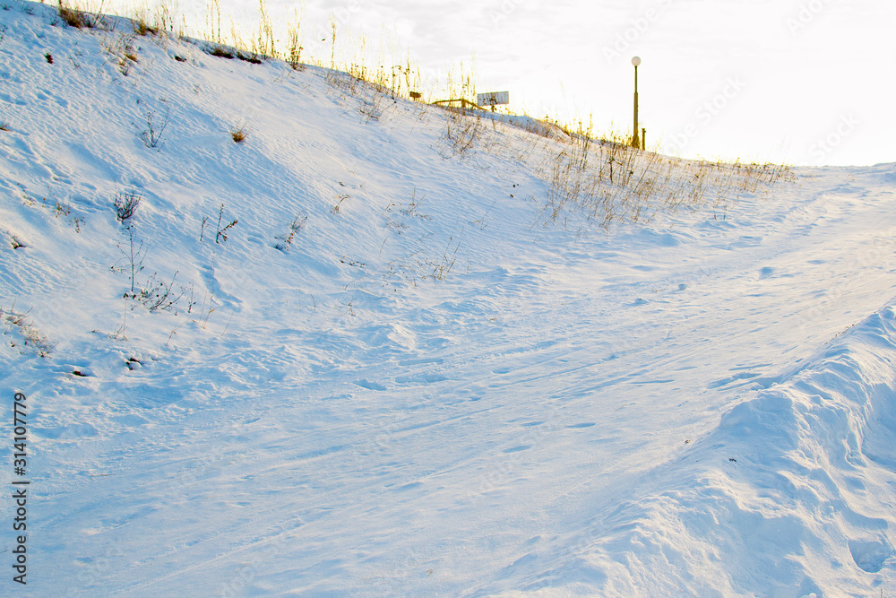 Obraz premium Company of friends ride down by snowing hill with snow tube The child laughs and smiles in winter park.