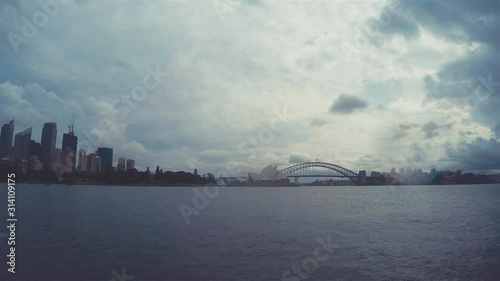 Sydney Harbour Bridge Time Lapse & Sydney Opera House Skyline. Cloudscape Shot In New South Wales Australia From Royal Botanical Gardens On Rainy Day Over Seawater With Cloudy Stormy Sky