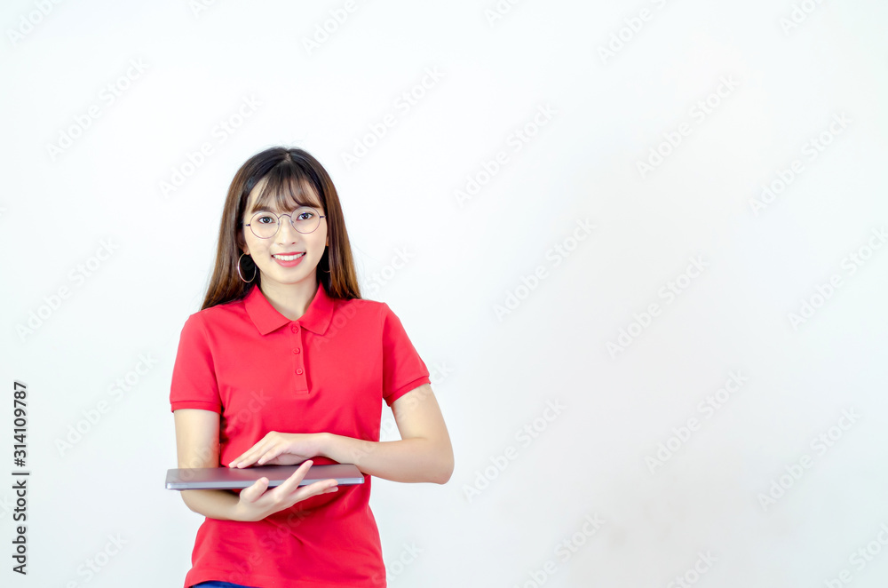 A beautiful Asian woman wearing a red shirt, eyeglasses, smiling with a notebook computer. A beautiful Asian woman wearing a red shirt, eyeglasses, smiling with a notebook computer.