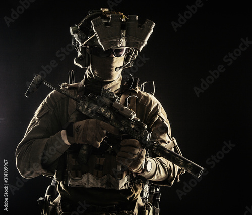 Elite commando fighter  private military company mercenary  special operations serviceman  security or secret service shooter equipped modern weapons and ammunition  studio shoot on black background