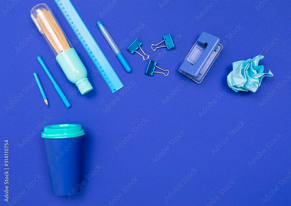 minimalism concept. stationery on a blue office desk minimalism concept. stationery on a blue office desk
