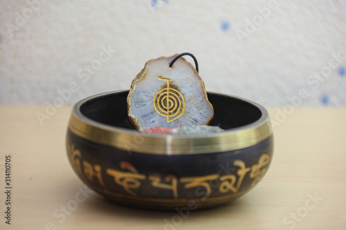 Fotografija Agate crystal in the Tibetan singing bowl with the reiki symbol Cho Ku Rei