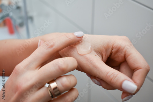 Woman applying moisturizing hand cream 