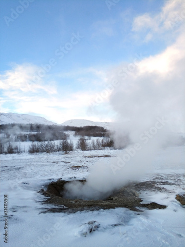 An erupting soaring geyser in the Valley of Geysers. Magnificent Iceland in the winter.