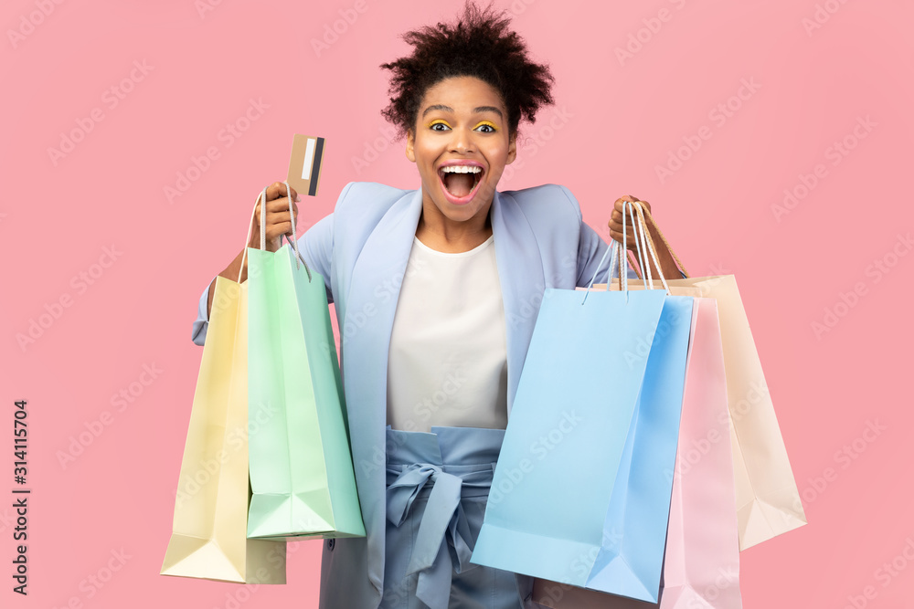 Cheerful afro girl holding shopping bags and plastic card Cheerful afro girl holding shopping bags and plastic card