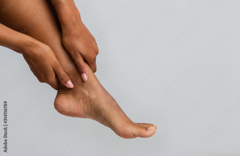 Close up of black woman massaging her ankle