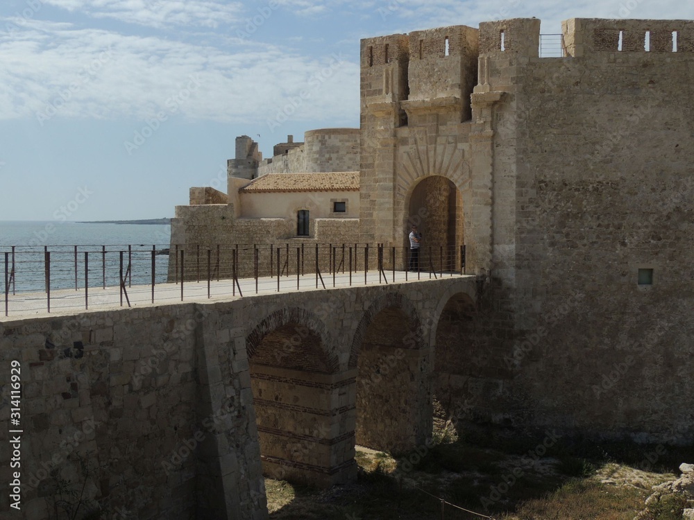 Siracusa Ortigia island – Maniace Castle sorrounded by the sea with stone walls and accessible by a stone bridge