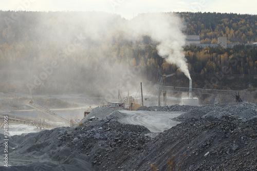 White dust cloud over working mining enterprise.