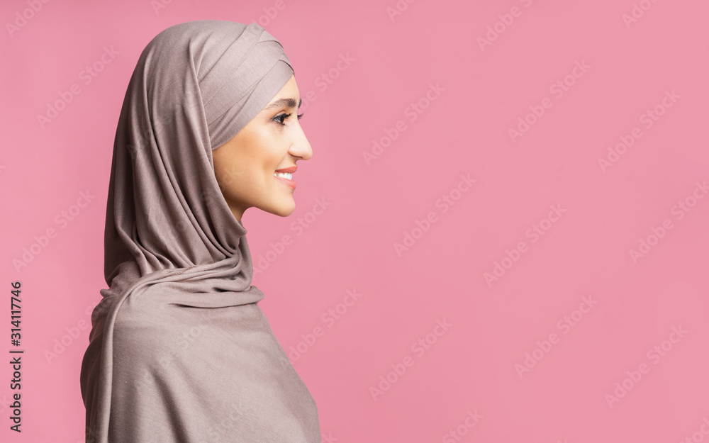 Profile portrait of beautiful arabic woman in hijab over pink background Profile portrait of beautiful arabic woman in hijab over pink background